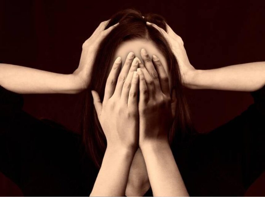 Imagen surrealista de una mujer que tiene 4 manos, con dos de ellas se toca la cabeza y con las otras dos se cubre el rostro.