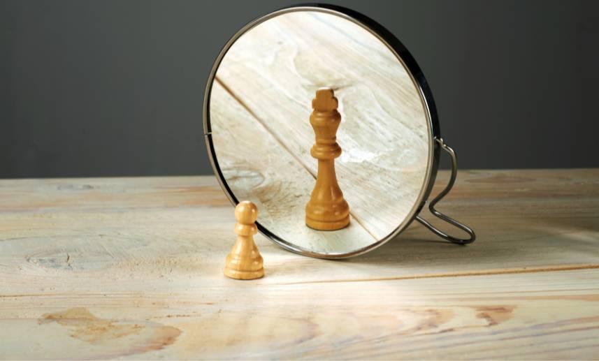Una pieza de ajedrez llamada peón, ve en el espejo una pieza llamada rey.