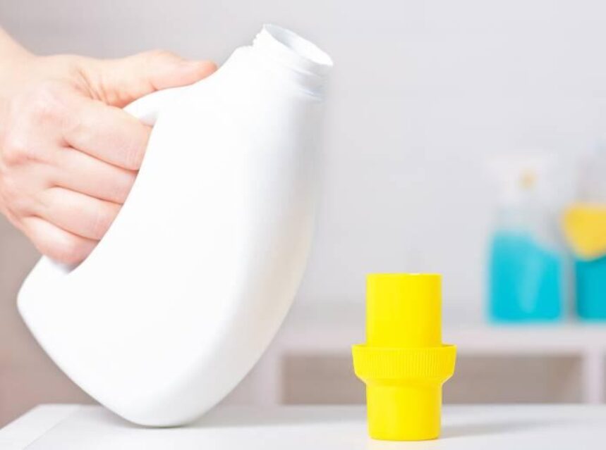 Botella de plástico normalmente usada para detergente de ropa en una mesa.