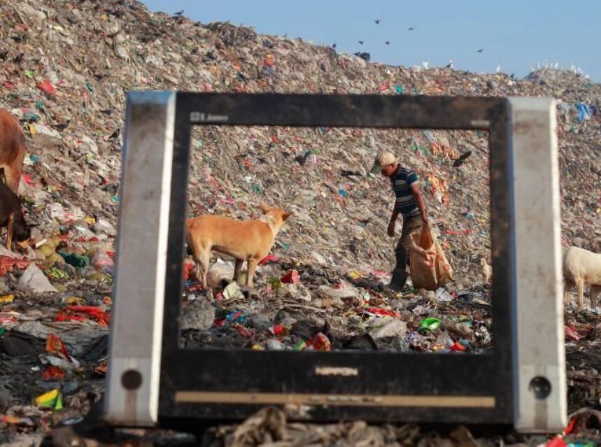 Hombre y un can caminando entre la basura.