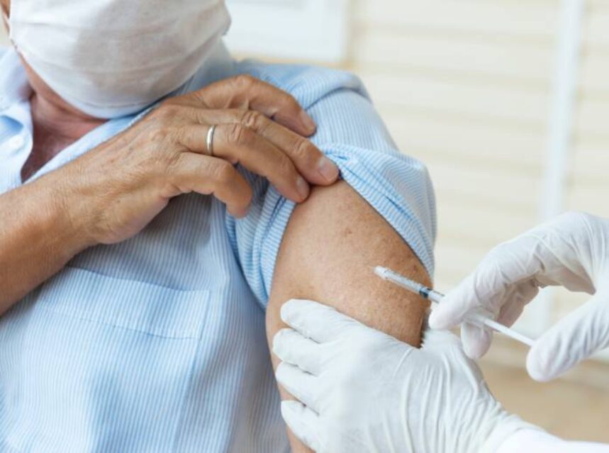 Hombre recibe vacuna en su brazo.