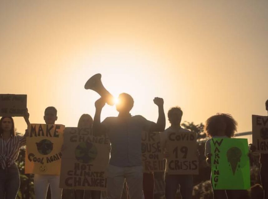 Jóvenes en manifestación con un cielo soleado.