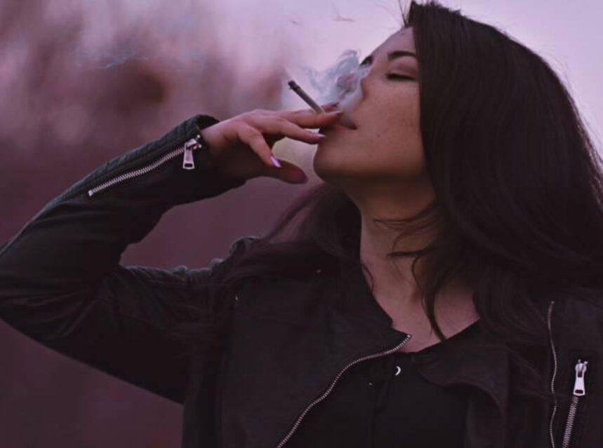 Mujer fuma un cigarro.