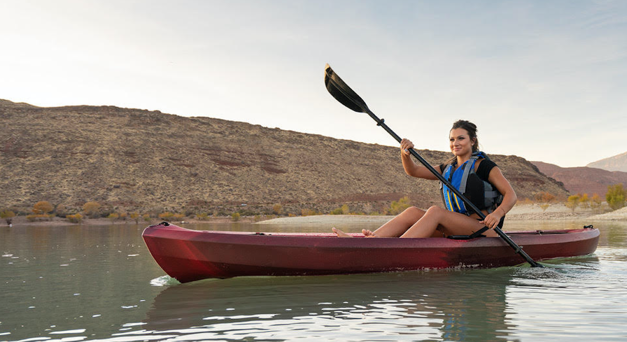Mujer en kayak por un lago