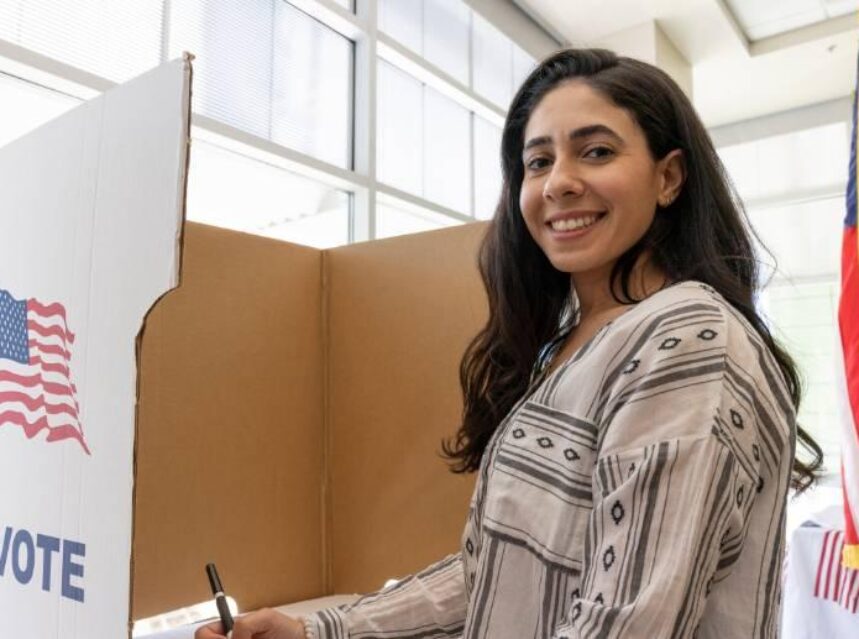 Joven mujer sonriente emite su voto.