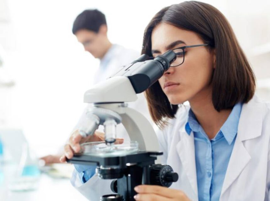 Una científica está analizando unas pruebas con un microscopio.