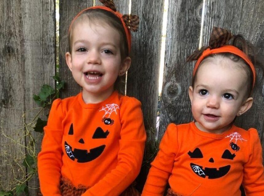 Dos niñas vestidas con trajes de pumpkins. Aprende dónde pedir dulces en halloween.