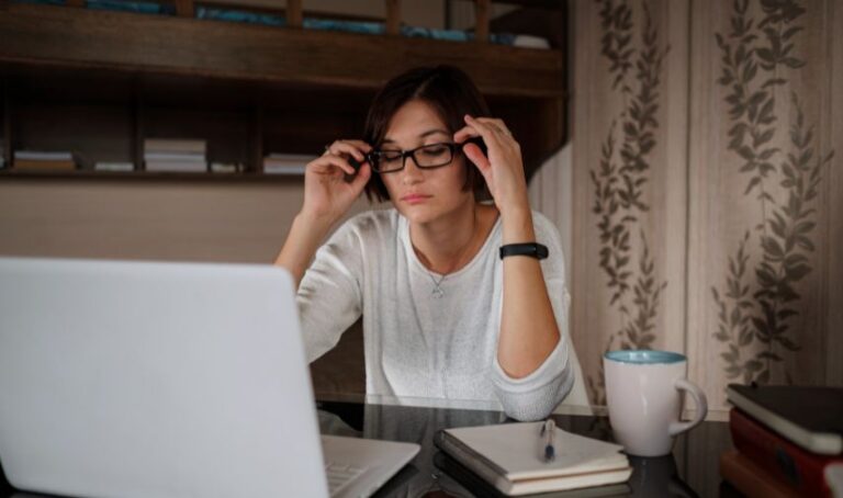 Una mujer en escritorio con su laptop, analiza sus finanzas.