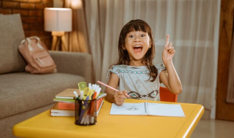 Una niña emocionada tiene una idea mientras está haciendo una tarea escolar.