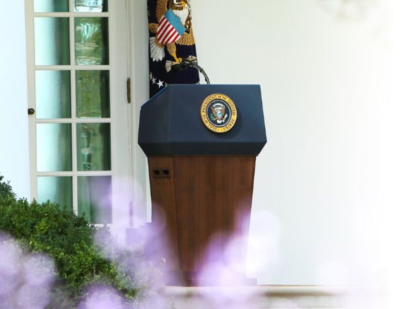 Podium para Presidente de EE.UU. entre destellos de luces moradas.