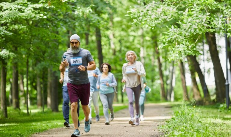 Personas adultas mayores corriendo en un bosque.