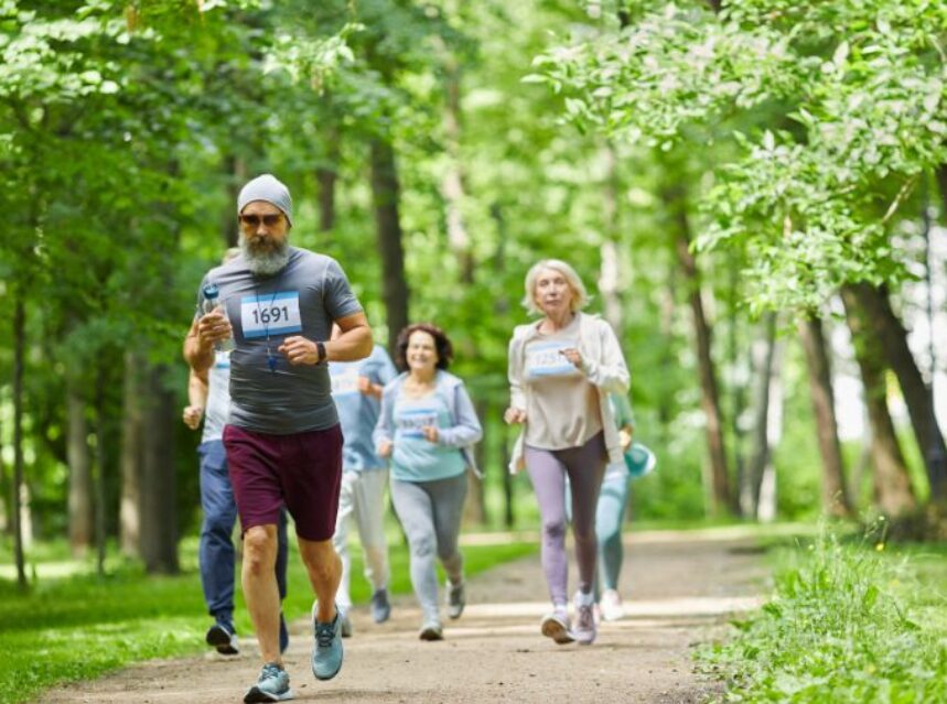 Personas adultas mayores corriendo en un bosque.