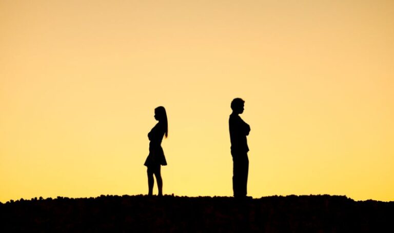 Una pareja de espaldas y con distancia considerable en un prado.