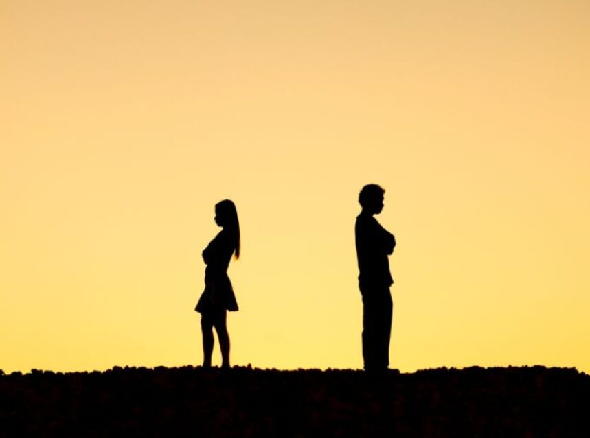 Una pareja de espaldas y con distancia considerable en un prado.