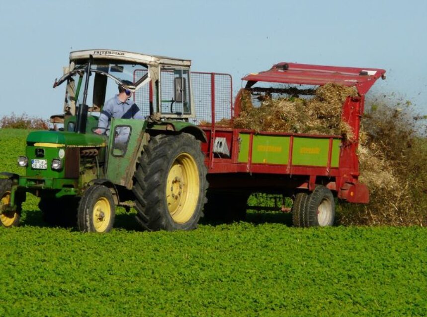 Una persona maneja un gran tractor en una granja.