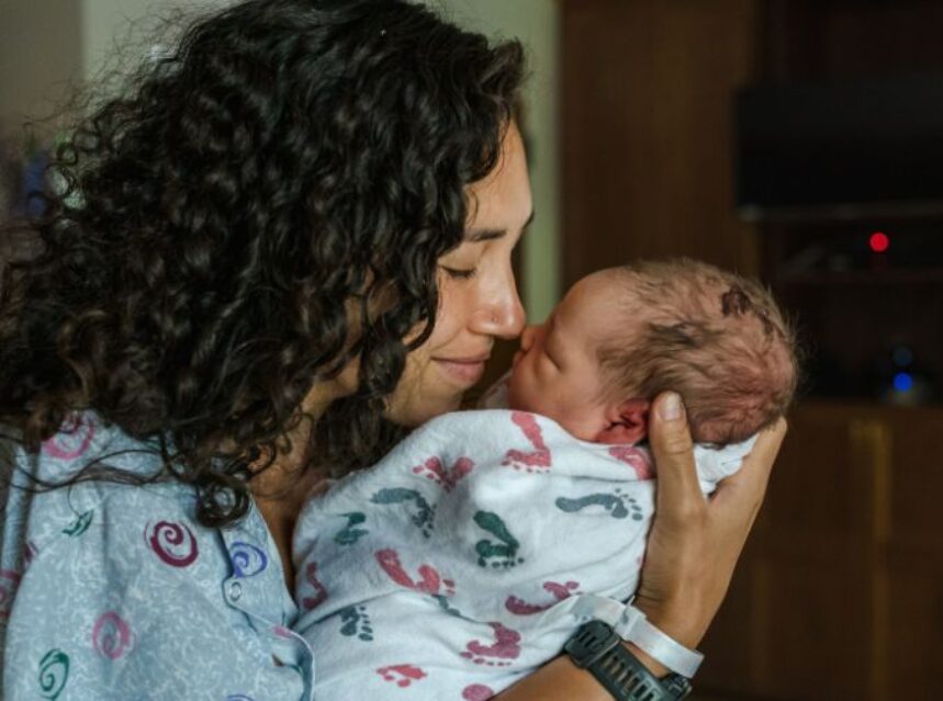 Una madre de un recién nacido une su nariz con la del bebé.