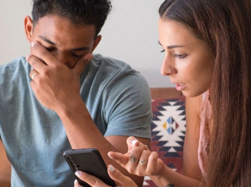 Una pareja mira a un celular.