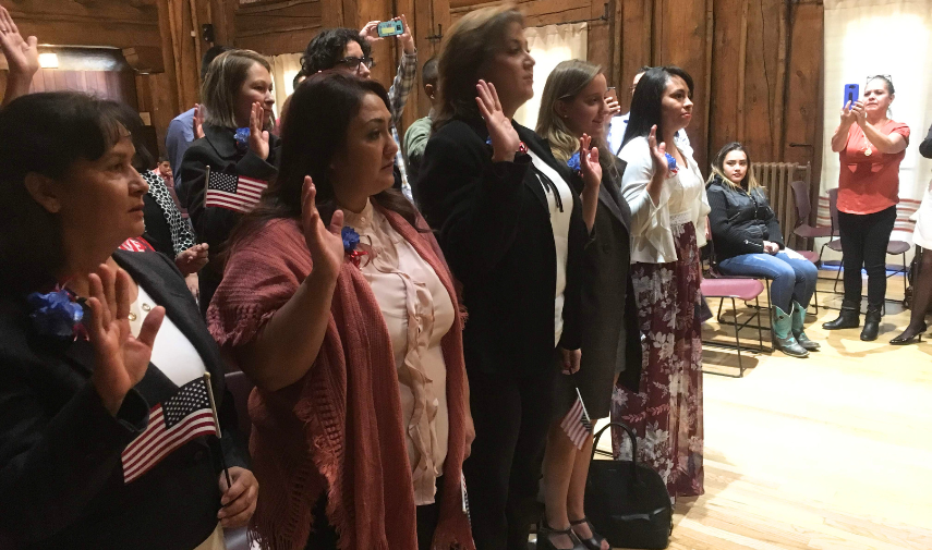 a group of people standing in a room with flags