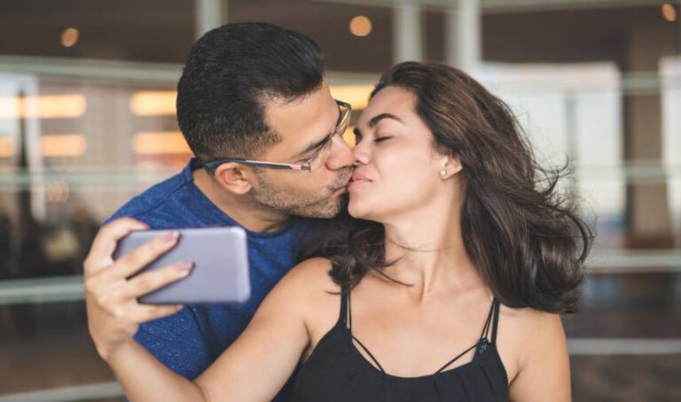 a man kissing a woman selfie