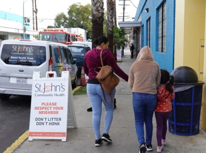 Familia latina camina por la acera.