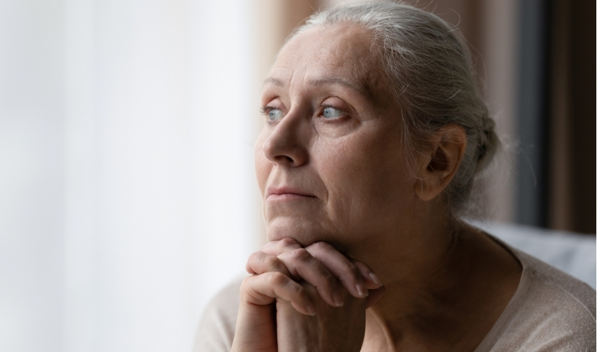 Mujer mayor reflexionando sola en casa sobre la vejez y el final de la vida