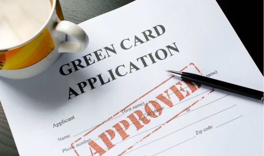 Empleado feliz con su Green Card tras obtener la residencia legal en EE.UU. gracias al patrocinio de su empleador.