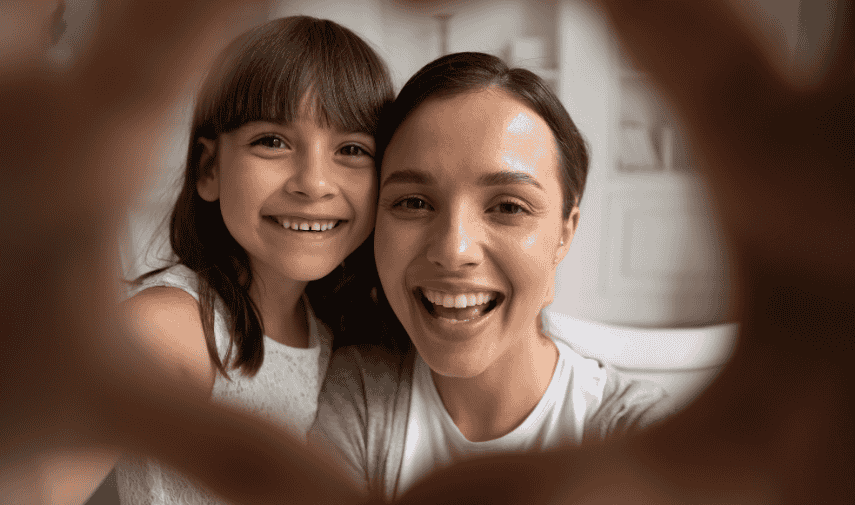 Mama e hija sonrien a la camara.